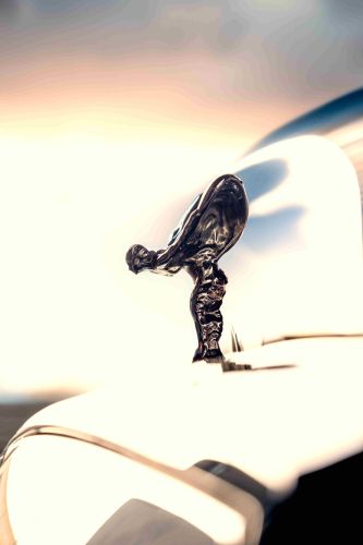 The Spirit of Ecstasy stands poised in dark chrome,