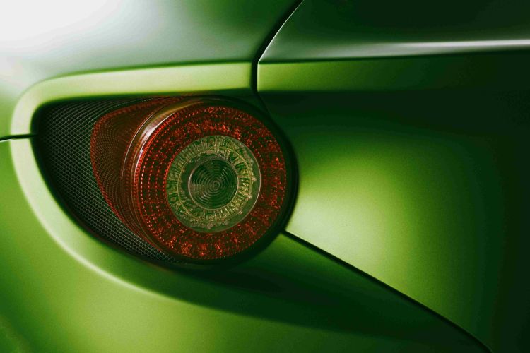 A vibrant green sports car reveals